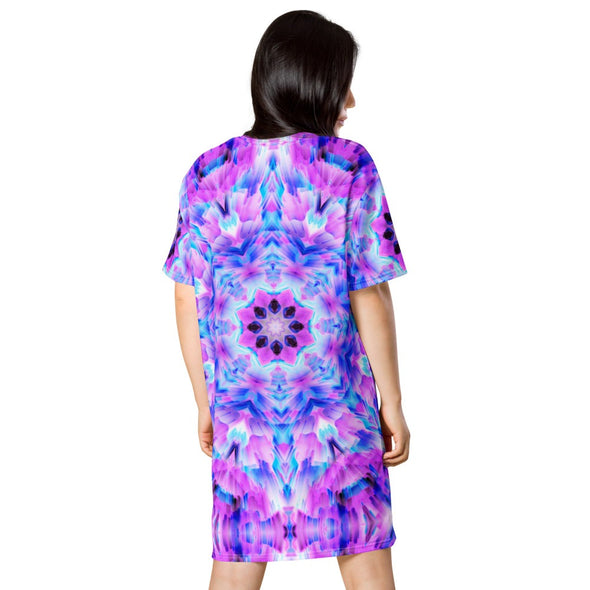 Photograph of a model wearing a Bleace unisex MetaParty Vibes Kaleidoscopic pink, light blue, Trippy Visual tee shirt dress.  