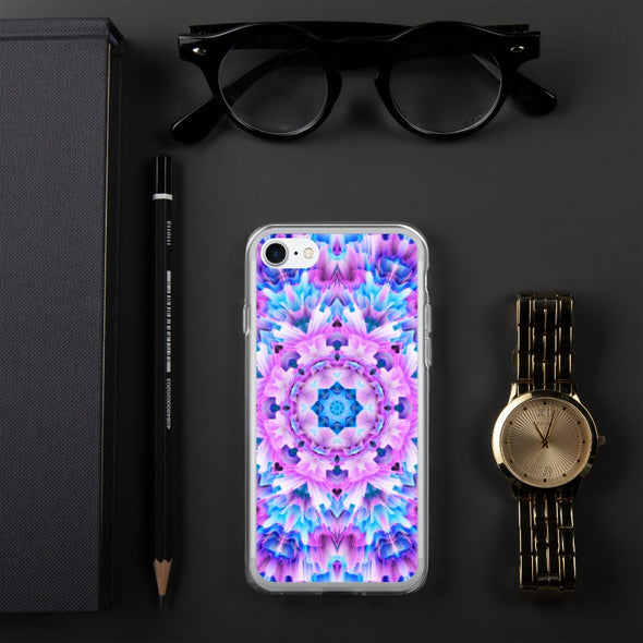 Product photograph of a Bleace Iphone case that has a kaleidoscope image made of pink, blue and purple colors in the foreground against a table backdrop next to a watch and eyeglasses.