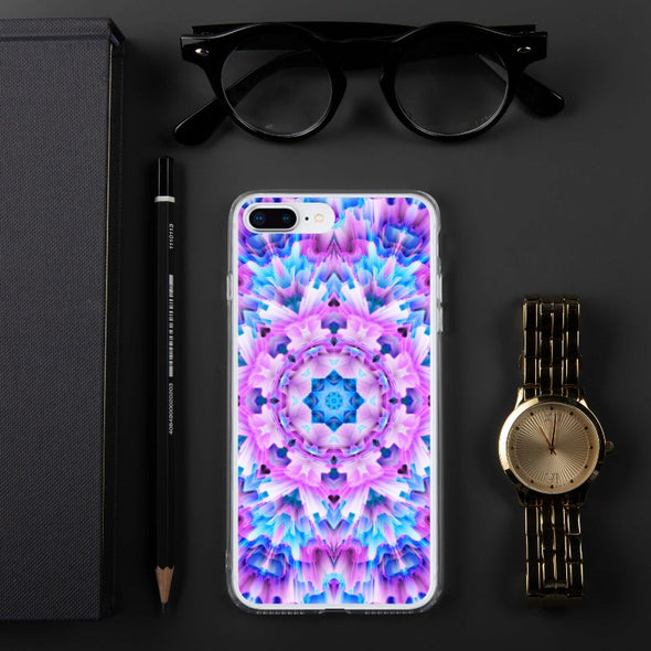 Product photograph of a Bleace Iphone case that has a kaleidoscope image made of pink, blue and purple colors in the foreground against a table backdrop next to a watch and eyeglasses.